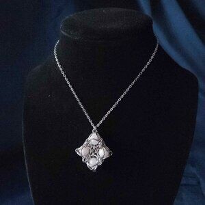 White pearl diamond-shaped pendant on a silver chain necklace